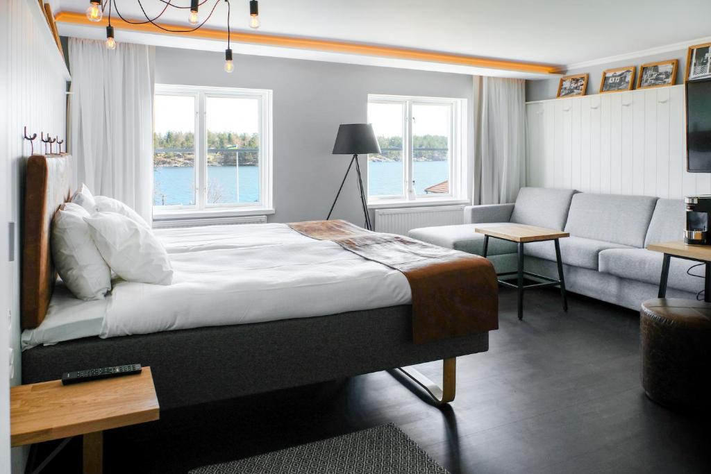 1 dormitorio con 1 cama y sala de estar con sofá en Hotell Furusund, en Furusund