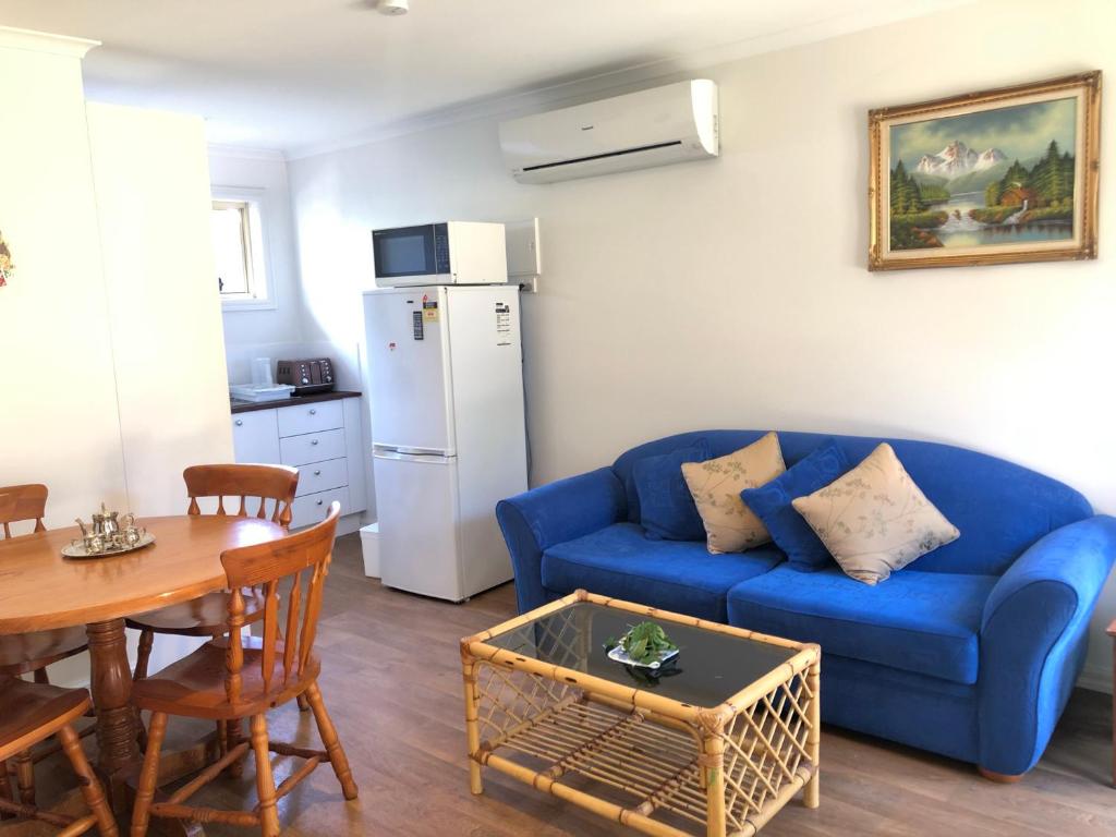 a living room with a blue couch and a table at Charlie sweet home at Mornington Peninsula in Mount Martha