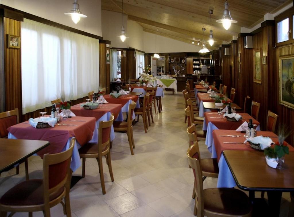 a row of tables in a restaurant with tables and chairs at Hotel Signorini in Castiglioncello