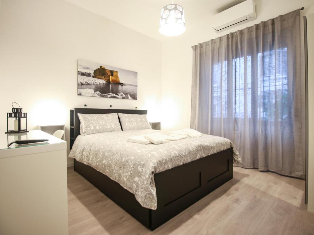 ChilometroZERO luxury apartment في نابولي: غرفة نوم بيضاء بها سرير ونافذة