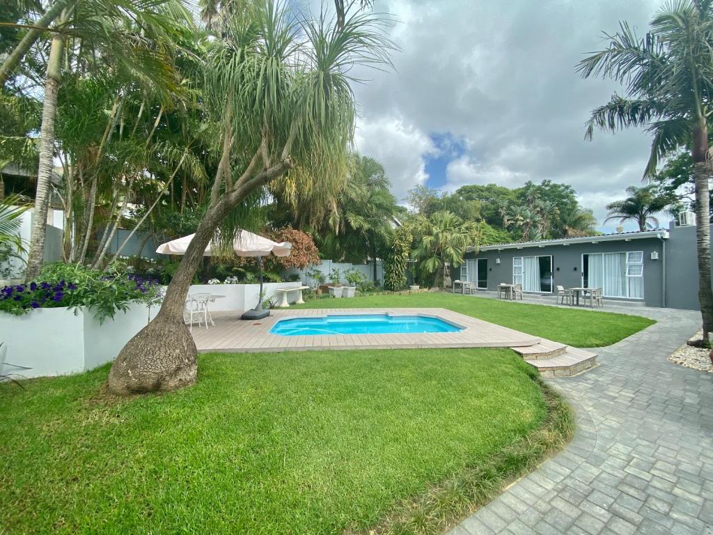 a backyard with a swimming pool and palm trees at 182 Old Transkei Road in East London