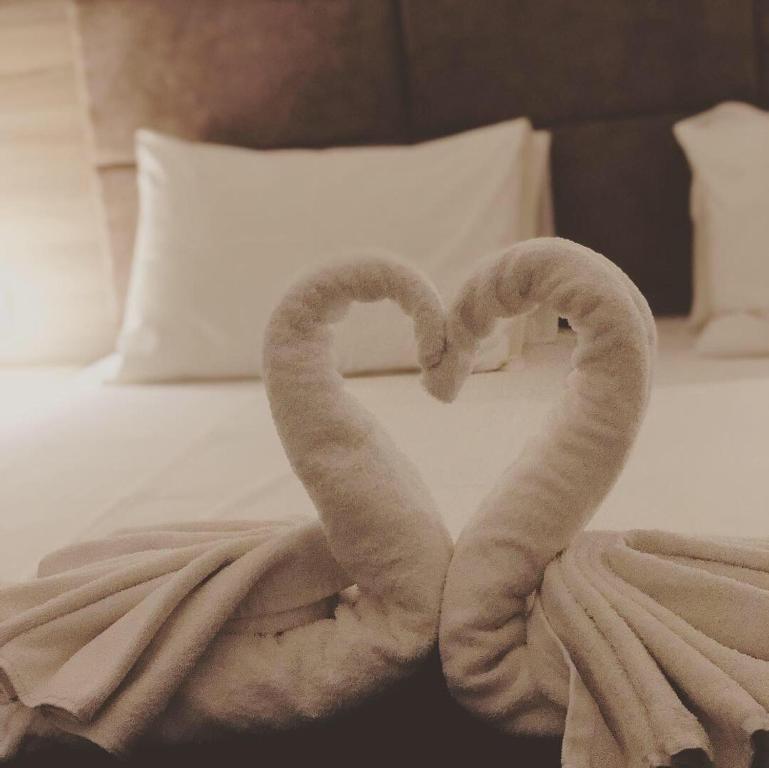 two towels shaped like hearts sitting on a bed at La Grotta in Volimes