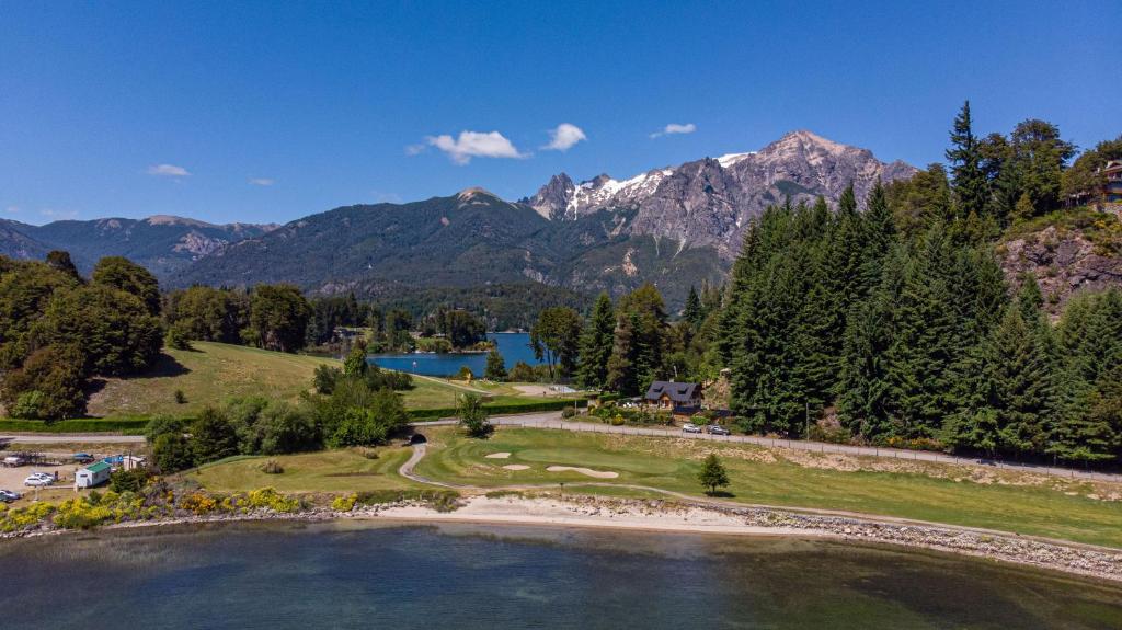 eine Luftansicht auf einen Golfplatz mit See und Bergen in der Unterkunft Casa en Llao Llao con vista al lago y campo de golf in San Carlos de Bariloche