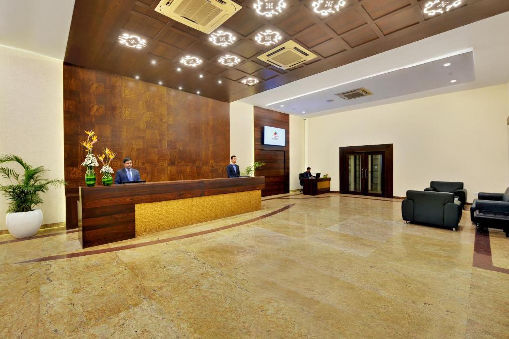 a lobby with two men standing at a reception desk at Manpho Bell Hotel & Convention Center in Bangalore