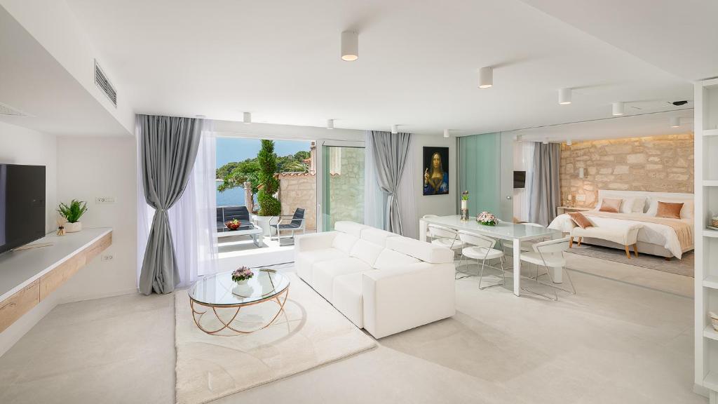 ein Wohnzimmer mit einem weißen Sofa und einem Tisch in der Unterkunft Villa Gariful in Hvar