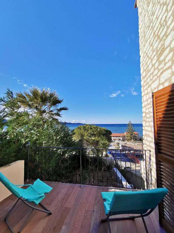 un balcon avec deux chaises et une vue sur l'océan dans l'établissement Domaine A Mortella T3, à Saint-Florent