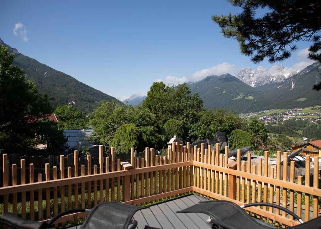 una valla de madera con sillas y montañas en el fondo en Chalet Gletscherblick Stubai, en Mieders