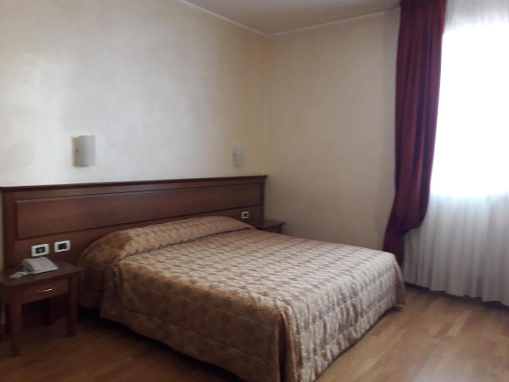 a hotel room with a bed and a window at ALBERGO RISTORANTE CAMPANILE AZZURRO in Villafranca Padovana