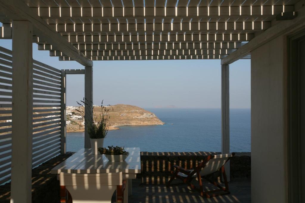 un patio con mesa y vistas al océano en Plan-B Holidays, en Playa Kalo Livadi