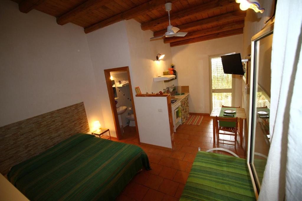 a bedroom with a bed and a kitchen with a refrigerator at L'Araucaria turismo rurale in Santa Croce Camerina