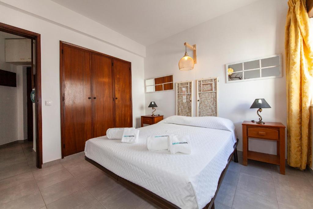 a bedroom with two beds and a wooden door at A32 - Postigo Apartment in Lagos in Lagos