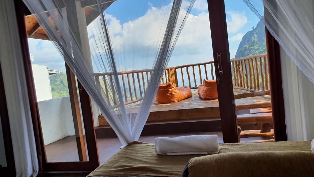 a bedroom with a balcony with a view of a mountain at Ella Mount View Guest Inn in Ella