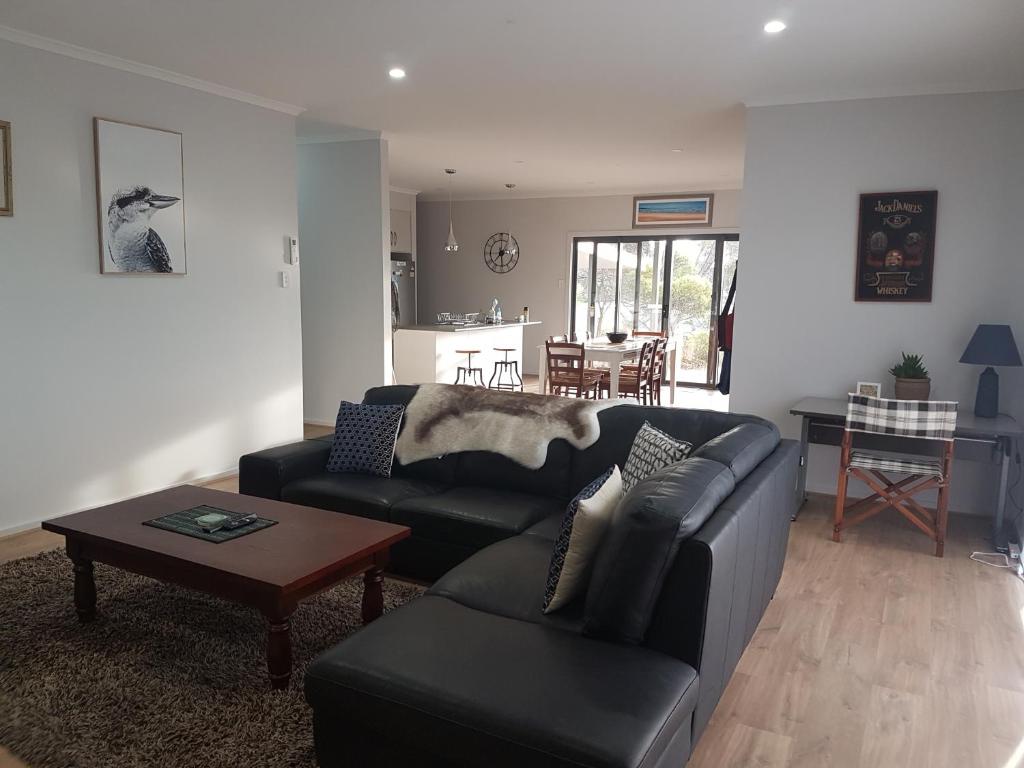 a living room with a black couch and a table at Gilligan's Kangaroo Island in Baudin Beach