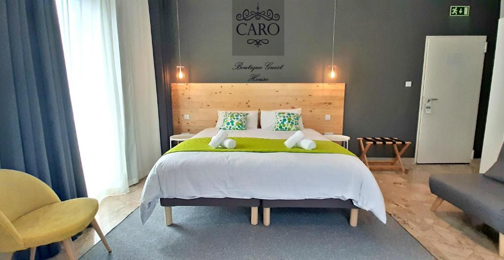 a bedroom with a large bed with a green blanket at CARO Boutique Guest House in San Ġwann