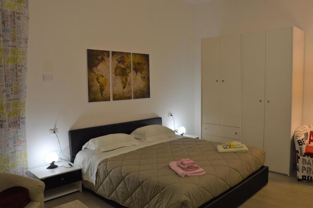 1 dormitorio con 1 cama y una pintura en la pared en L'angoletto, en Matera