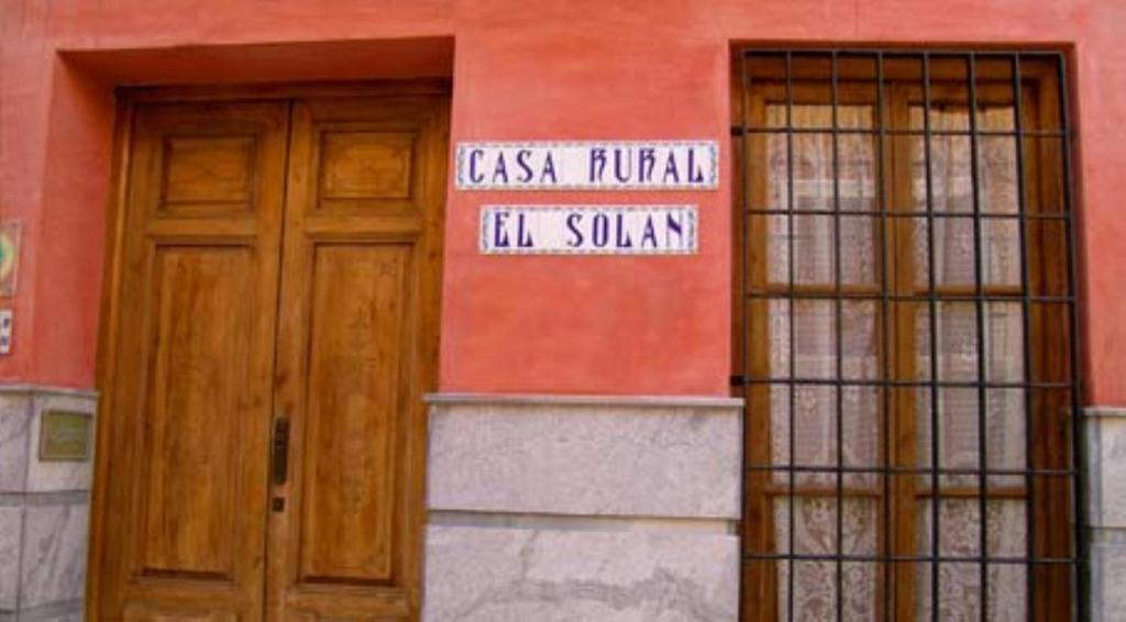 un edificio con dos puertas y una señal en él en Casa Rural El Solan, en Blanca