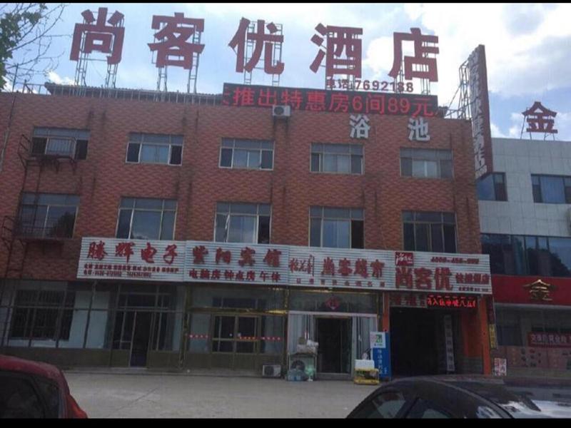 un gran edificio de ladrillo rojo con escritura en él en Thank Inn Chain Hotel shandong weifang fangzi district beihai road, en Weifang