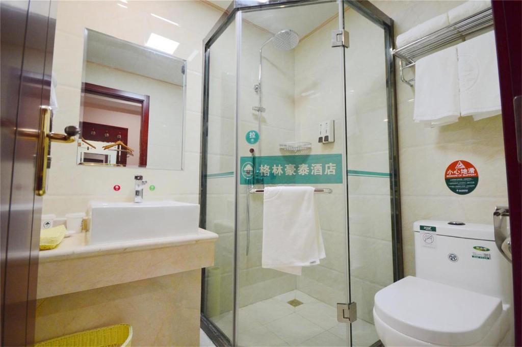 La salle de bains est pourvue d'une douche, de toilettes et d'un lavabo. dans l'établissement GreenTree Inn Baoding City Cangzhou Guanyun West Road Business Hotel, à Zhuozhou