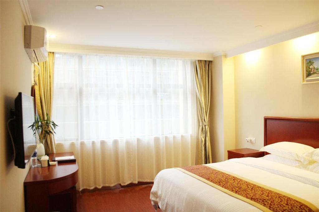 une chambre d'hôtel avec un lit et une fenêtre dans l'établissement GreenTree Inn Beijing Yanqing District Badaling Changcheng Kangzhuang Smart Choice Hotel, à Yanqing