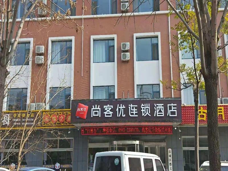 BinzhouにあるThank Inn Chain Hotel shandong binzhou bincheng district vocational collegeの建物前に停車する白いバン