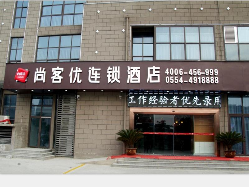 een gebouw met Aziatische letters op de voorkant bij Thank Inn Chain Hotel anhui huinan shou county rose residence in Huainan