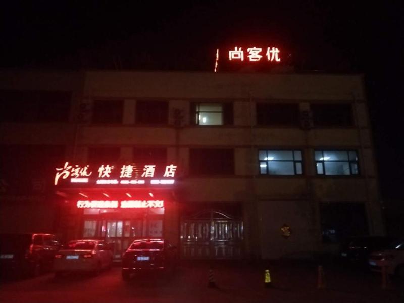 un edificio con un cartel encima por la noche en Thank Inn Chain Hotel shandong linyi lanshan district west outer ring road en Linyi