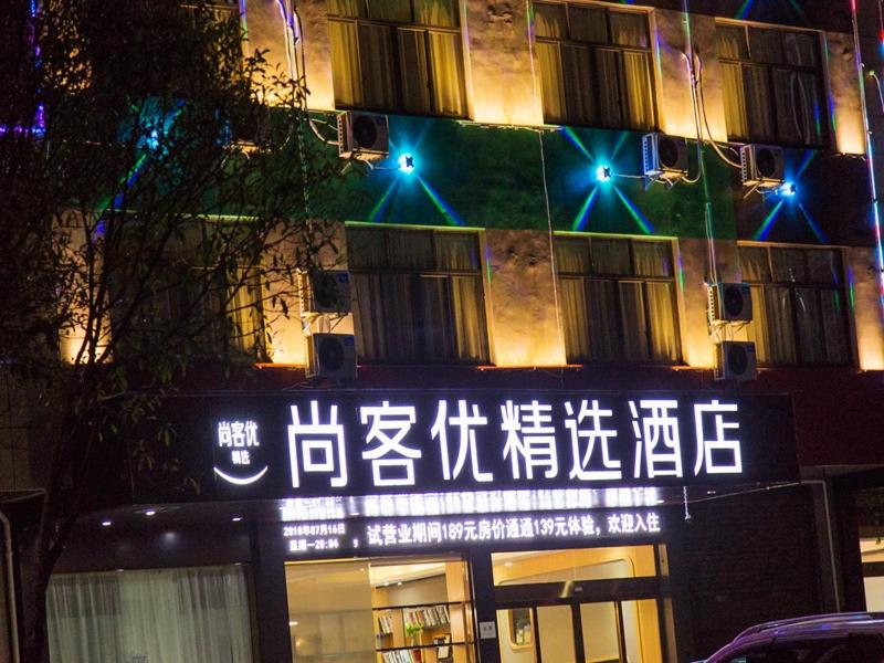 un edificio con un cartel en el costado en Thank Inn Plus Hotel jingxi shangrao economic development zone jingke avenue, en Shangrao