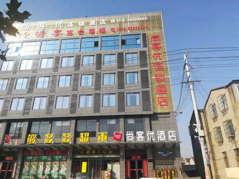 Un bâtiment avec un panneau en haut dans l'établissement Thank Inn Chain Hotel jiangsu xuzhou jiawang district biantang county, à Xuzhou