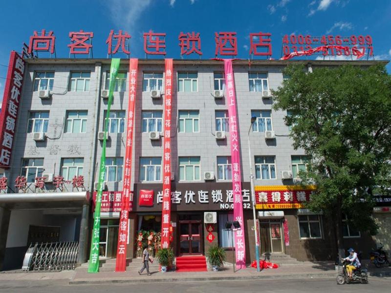 a building with writing on the front of it at Thank Inn Chain Hotel hebei zhangjiakou xia garden district railway station in Zhangjiakou