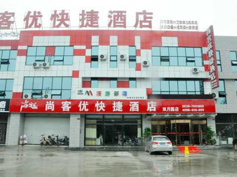 Thank Inn Chain Hotel shandong linyi shuangyue garden road في ليني: مبنى متوقف امامه سيارة