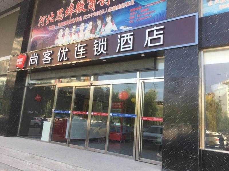 a store with a sign on the side of a building at Thank Inn Chain Hotel hebei handan wei county tian'an avenue chinese medicine hospital in Handan