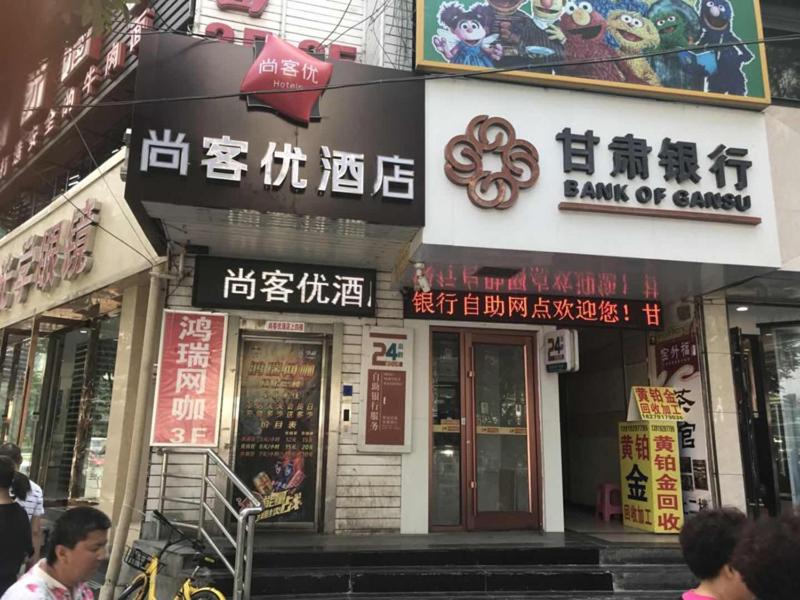 un edificio con letreros en el costado en Thank Inn Chain Hotel gansu lanzhou chengguan district oriental red square en Lanzhou