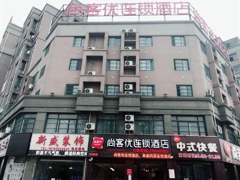 阜陽にあるThank Inn Chain Hotel anhui fuyang funan county governmentの表札のある高層ビル