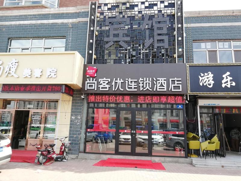 un groupe de bâtiments dans une rue urbaine dans l'établissement Thank Inn Chain Hotel heilongjiang harbin songbei district ice and snow world, à Harbin