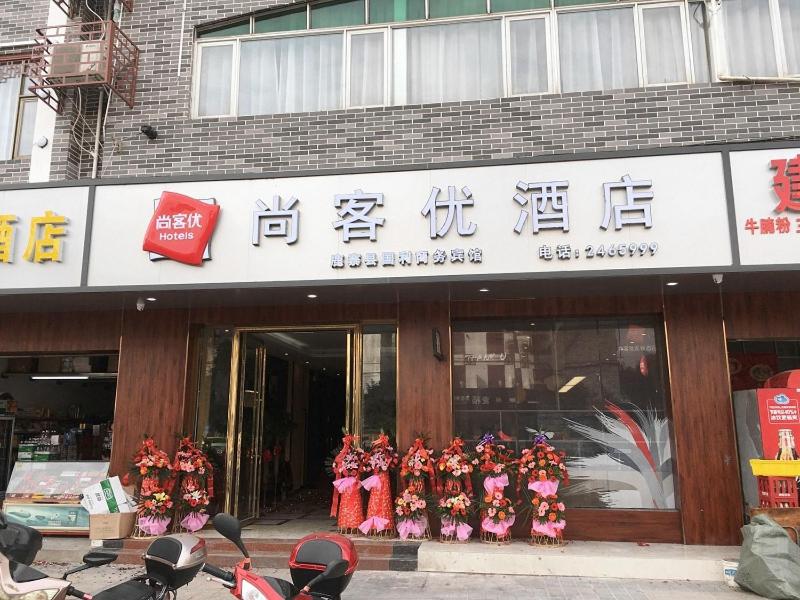 una tienda con un grupo de personas en uniformes rojos en Thank Inn Chain Hotel guangxi liuzhou luzhai county square, en Liuzhou