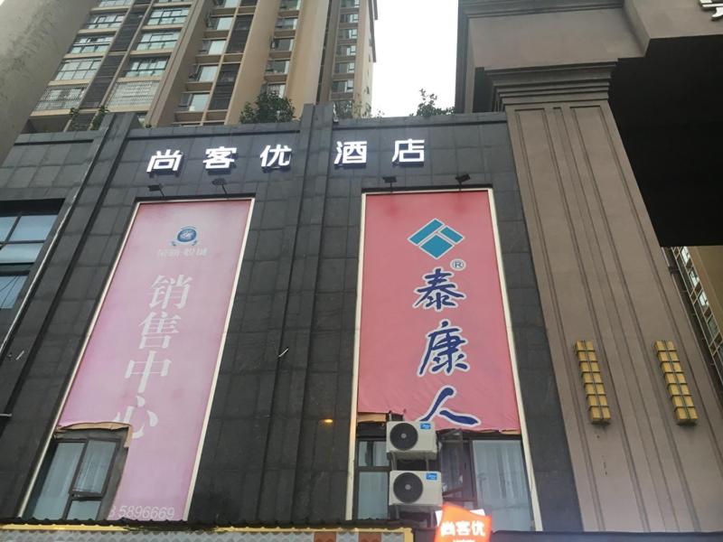 un edificio con letreros en el costado en Thank Inn Chain Hotel sichuan guang'an yuechi rongxinyue city, en Guang'an