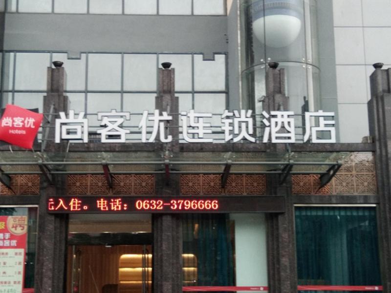 Thank Inn Chain Hotel Shandong zaozhuang central district ginza mall في Zhaozhuang: علامة على جانب مبنى عليه كتابة