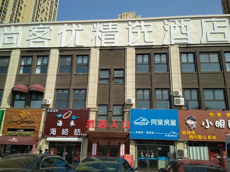 duży budynek z napisem na boku w obiekcie Thank Inn Plus Hotel Shandong Qingdao Licang Wan Nianquan Road w mieście Qingdao