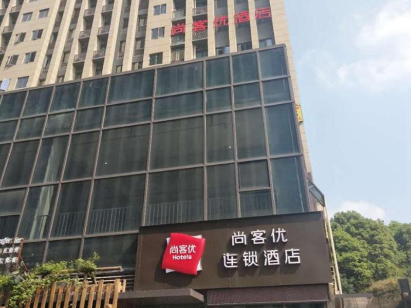 un grand bâtiment avec un panneau devant lui dans l'établissement Thank Inn Chain Hotel Chongqing nanan district tongjing international store, à Chongqing