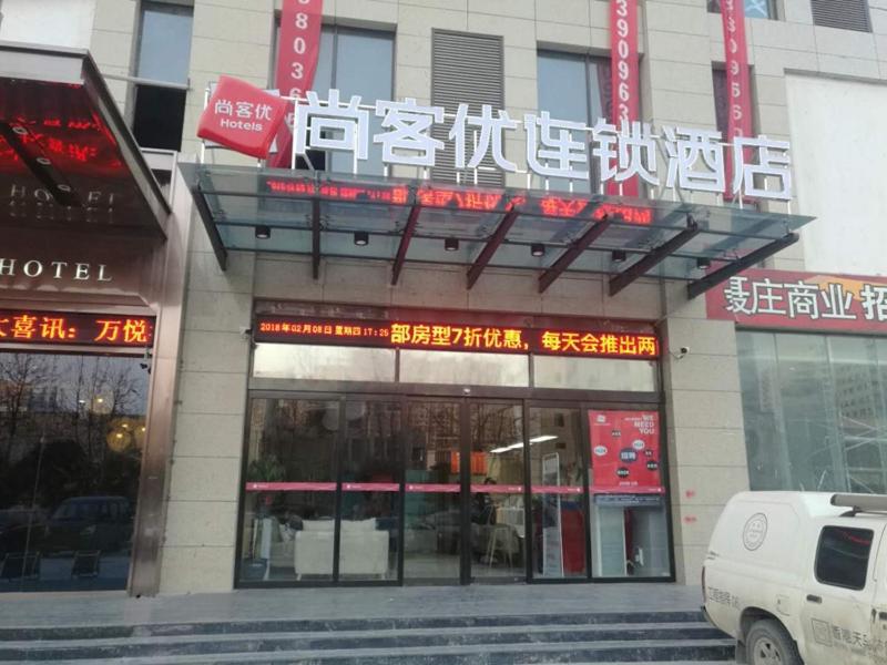 ein Gebäude mit einem Schild für ein Hotel in der Unterkunft Thank Inn Chain Hotel henan zhengzhou future road convention and exhibition center in Zhengzhou