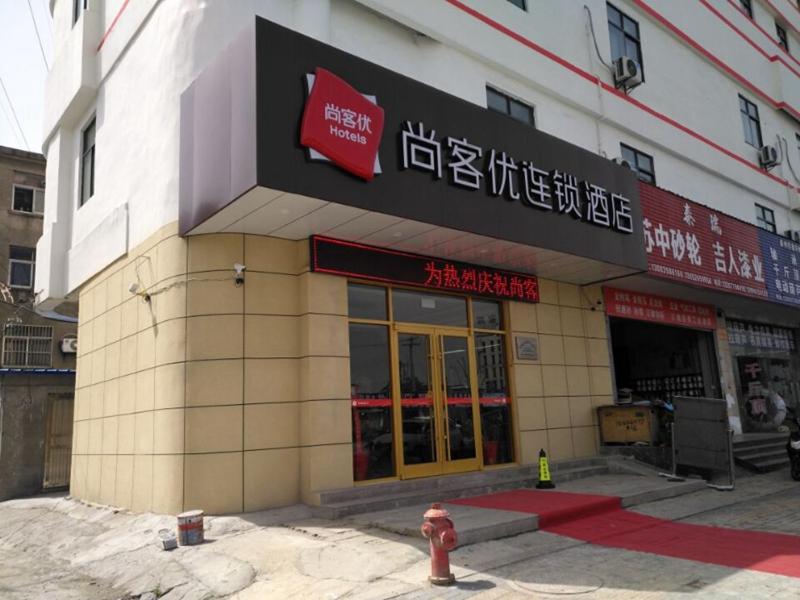 un edificio con una boca de incendios delante de él en Thank Inn Chain Hotel Jiangsu Taizhou West Passenger Station Jianhang Store en Taizhou