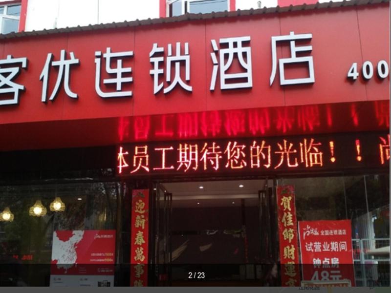 czerwony budynek z chińskim napisem w obiekcie Thank Inn Chain Hotel jiangxi yichun zhangshu city cultural square w mieście Zhangshu