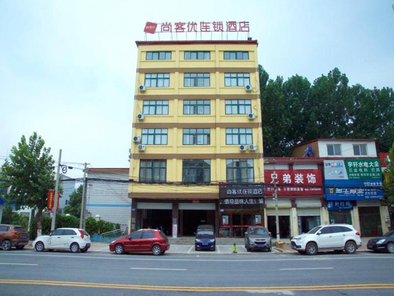 un edificio amarillo con coches estacionados frente a él en Thank Inn Chain Hotel henan kaifeng jinming district xinghuaying town government, en Kaifeng