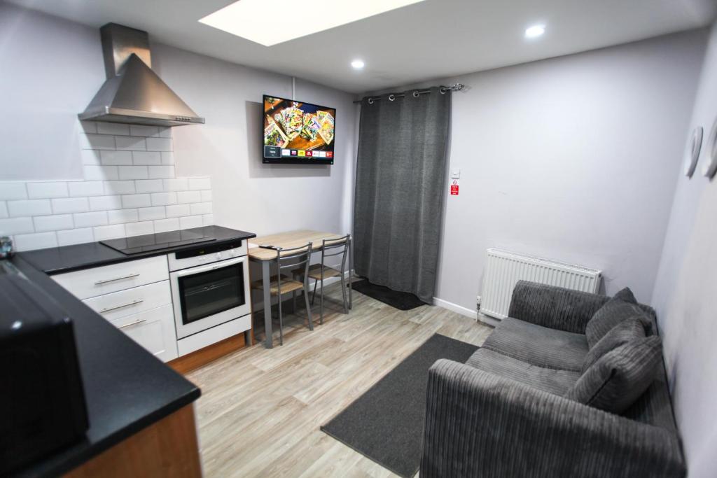 sala de estar con sofá y cocina en 1B Smart Apartments, en Newark-on-Trent