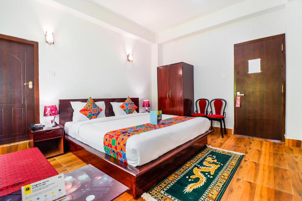 um quarto com uma cama grande e uma cadeira vermelha em FabHotel Greenery View Middle Lingding ICAR Road em Gangtok