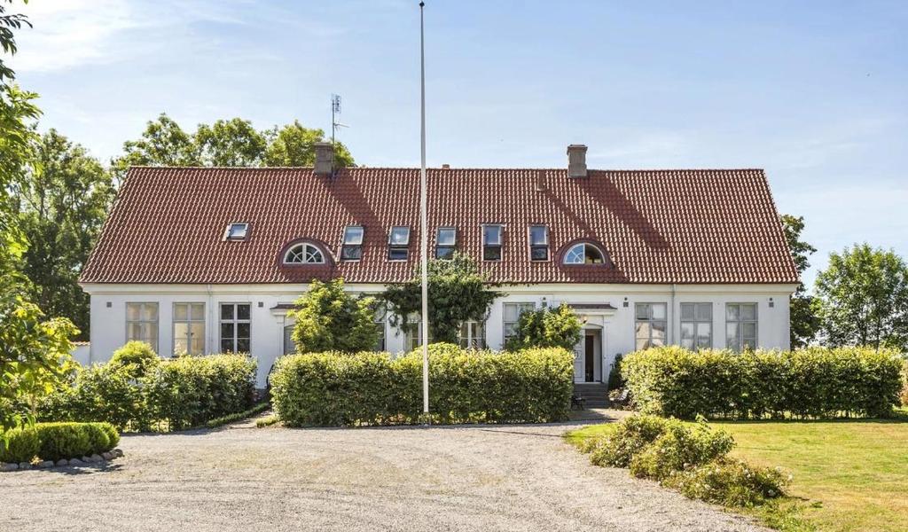 ein großes weißes Haus mit rotem Dach in der Unterkunft Hedmansgården in Västra Torp