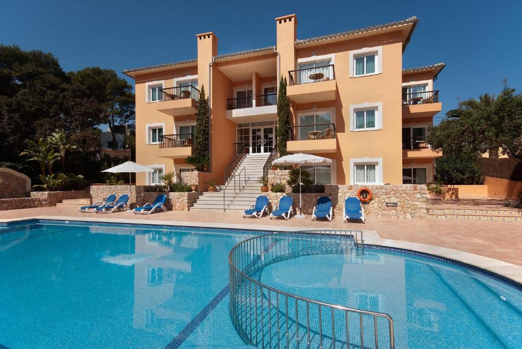 a swimming pool in front of a building at PINOS ALTOS 12 in Cala de Sant Vicenc