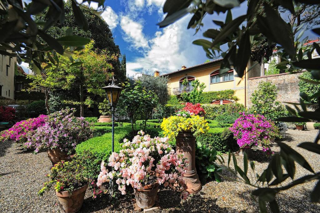 un jardín lleno de flores en jarrones en Hotel Monna Lisa en Florence