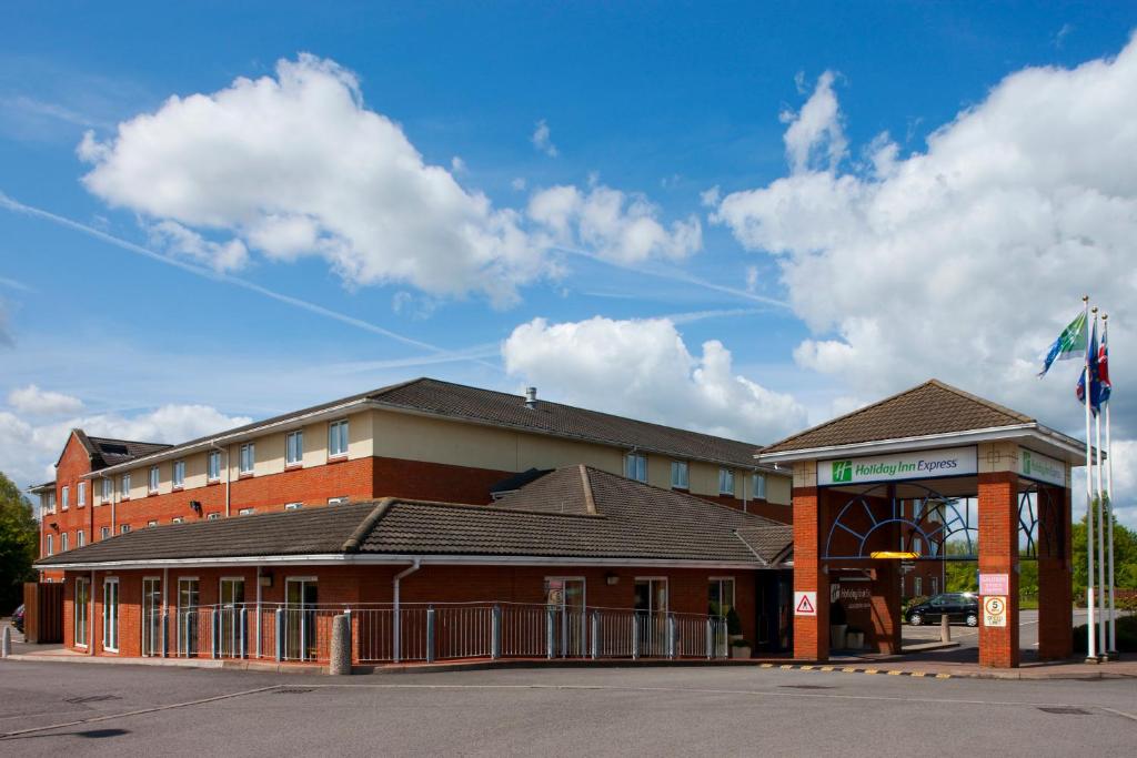 um edifício de tijolos com uma bandeira em frente em Holiday Inn Express Gloucester - South, an IHG Hotel em Gloucester