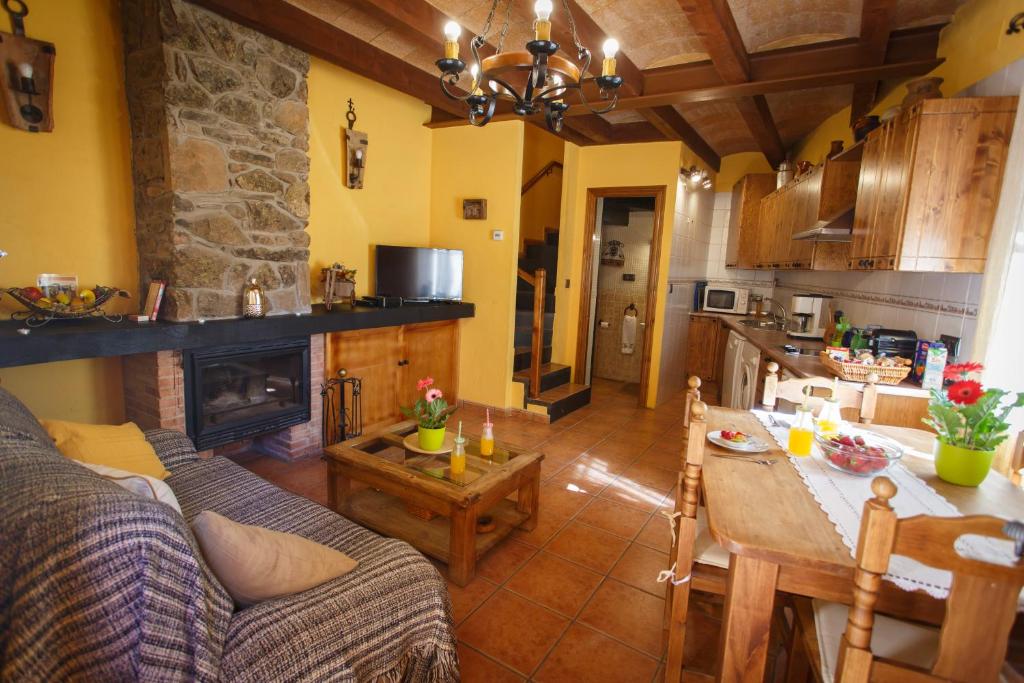 cocina y sala de estar con sofá y mesa en El Bulín de Braojos - 3 Casas en Braojos de la Sierra